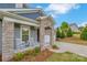 Welcoming front porch with stone pillars, rocking chairs, and a well-maintained garden at 504 Gardenbrook Trl, Belmont, NC 28012