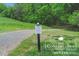 Community trail entrance featuring a trail and pond rules sign on a well-manicured lawn at 504 Gardenbrook Trl, Belmont, NC 28012