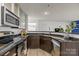 Modern kitchen with stainless steel appliances, granite countertops, dark cabinets, and wood-look flooring at 505 N Graham St # 2H, Charlotte, NC 28202