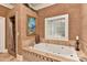 Elegant bathroom features a luxurious soaking tub and a separate shower with travertine tile at 505 S South St, Gastonia, NC 28052