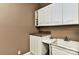 Functional laundry area with white cabinets, countertop, and a deep utility sink at 505 S South St, Gastonia, NC 28052