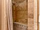 Spacious walk-in shower is adorned with travertine tile and decorative accents at 505 S South St, Gastonia, NC 28052