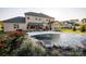 Landscaped backyard with a covered patio, outdoor seating, and a tranquil pool area, creating a private oasis at 5051 Hyannis Ct, Matthews, NC 28104
