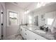 Clean bathroom featuring dual sinks with granite countertops, a large mirror, and bright lighting at 5051 Hyannis Ct, Matthews, NC 28104