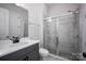 Modern bathroom with a glass-enclosed shower featuring marble-look tile, complemented by a gray vanity and neutral decor at 5051 Hyannis Ct, Matthews, NC 28104