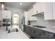 Modern kitchen with white and gray cabinets, quartz countertops, stainless steel appliances, and breakfast bar for entertaining at 5051 Hyannis Ct, Matthews, NC 28104