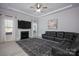 This comfortable living room has a ceiling fan, fireplace, large TV, rug, and plenty of room to entertain at 5051 Hyannis Ct, Matthews, NC 28104