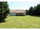 View of home's back exterior featuring a wooden porch and a spacious, well-maintained lawn at 5065 Gateway Dr, Claremont, NC 28610