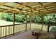 Covered back porch with wooden railings and a small table with ride-on toy at 5065 Gateway Dr, Claremont, NC 28610