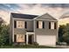 Charming two-story home featuring a welcoming entrance, a two-car garage and a beautifully landscaped front yard at 5066 Beargrass Dr, Dallas, NC 28034
