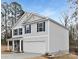 Side view of a two-story home showcasing light gray siding, dark blue shutters, and a two-car garage at 5124 Fireweed Ct, Dallas, NC 28034