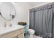 Clean and bright bathroom with a vanity, toilet, and shower featuring a stylish curtain at 5184 Swinging Bridge Rd, Conover, NC 28613
