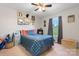 Comfortable bedroom featuring a plaid bedspread, window with curtains, and a toy storage area at 5184 Swinging Bridge Rd, Conover, NC 28613