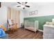 Charming Bedroom with hardwood floors, a rocking chair, and a classic white crib at 5184 Swinging Bridge Rd, Conover, NC 28613