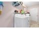 Bright laundry room featuring modern white washer and dryer, plus ample storage space on floating shelves at 5184 Swinging Bridge Rd, Conover, NC 28613