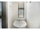 Stylish half bathroom features a vessel sink, modern fixtures, and a view from the window at 562 New Bern Station Ct, Charlotte, NC 28209