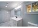 Bathroom with marble-look shower, modern vanity, and natural light from the window at 600 Burns St, Wadesboro, NC 28170