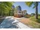 Two-story home featuring a front porch, large yard, long driveway and mature trees at 600 Burns St, Wadesboro, NC 28170