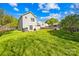 Backyard with green grass surrounding the house at 6418 Castlewynd Ct, Charlotte, NC 28212
