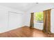 Bright bedroom featuring hardwood floors, closet and a window with beautiful natural light at 6418 Castlewynd Ct, Charlotte, NC 28212