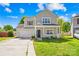 Charming two-story home featuring a covered front porch, attached garage, and well-maintained lawn on a sunny day at 6418 Castlewynd Ct, Charlotte, NC 28212