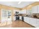 Well-lit kitchen featuring white cabinets, stainless steel appliances, and sliding glass doors at 6418 Castlewynd Ct, Charlotte, NC 28212