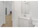 Bathroom with new vanity, sink, and mirror, next to a view to the living room at 6523 Clavell Ln, Charlotte, NC 28210