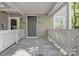 Inviting front porch with weathered wooden flooring and painted white railings offers charm and curb appeal at 6523 Clavell Ln, Charlotte, NC 28210