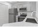 Updated kitchen features stainless steel appliances, gray cabinets with gold pulls, and granite countertops at 6523 Clavell Ln, Charlotte, NC 28210