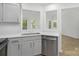 Updated kitchen features stainless steel appliances, gray cabinets with gold pulls, and granite countertops at 6523 Clavell Ln, Charlotte, NC 28210