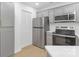 Updated kitchen features stainless steel appliances, gray cabinets with gold pulls, and wood flooring at 6523 Clavell Ln, Charlotte, NC 28210