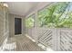 Well-lit side porch with white railings and wooden deck flooring offers a relaxing outdoor space to enjoy nature at 6523 Clavell Ln, Charlotte, NC 28210
