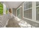 Comfortable side porch with ample natural light and wooden deck flooring offers a relaxing outdoor space at 6523 Clavell Ln, Charlotte, NC 28210