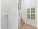 Staircase with neutral carpet, white railing, and large window with plantation shutters at 6523 Clavell Ln, Charlotte, NC 28210