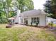 Lush backyard featuring a dining set, brick fire pit, and green lawn, creating a perfect outdoor living space at 8623 Cedar Hollow Ln, Huntersville, NC 28078
