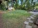 View of the backyard showcasing mature trees, shed, stone pathway, fire pit and lush lawn at 8623 Cedar Hollow Ln, Huntersville, NC 28078