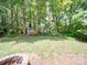 Lush backyard featuring a shed, mature trees and green space, perfect for outdoor activities and relaxation at 8623 Cedar Hollow Ln, Huntersville, NC 28078