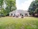 Expansive backyard with patio, dining set, fire pit, lush greenery, and fenced-in yard, perfect for outdoor enjoyment at 8623 Cedar Hollow Ln, Huntersville, NC 28078