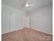 Well-lit bedroom with carpeting, a ceiling fan, closet doors and a large window, ideal for relaxation at 8623 Cedar Hollow Ln, Huntersville, NC 28078