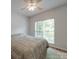 Bright bedroom featuring a ceiling fan, large window with blinds, and a comfortable queen-size bed at 8623 Cedar Hollow Ln, Huntersville, NC 28078