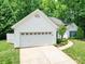 Side view of a single-story home with an attached two-car garage and a concrete driveway at 8623 Cedar Hollow Ln, Huntersville, NC 28078