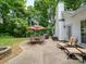 Serene patio space with an umbrella-covered dining table and lounge chairs, framed by lush greenery at 8623 Cedar Hollow Ln, Huntersville, NC 28078