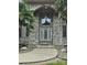 Close up of the front entrance featuring a leaded glass door framed by a brick archway and manicured landscaping at 9535 Potter Rd, Matthews, NC 28104