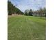 An expansive green lawn leads up to a stately brick home with a manicured landscape at 9535 Potter Rd, Matthews, NC 28104