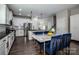 Modern kitchen with white cabinets, stainless steel appliances, black countertops, and a marble-topped dining table at 9860 Darby Creek Nw Ave, Concord, NC 28027