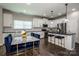 Modern kitchen with white cabinets, stainless steel appliances, black countertops, and a marble-topped dining table at 9860 Darby Creek Nw Ave, Concord, NC 28027