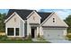 Charming home exterior with gray siding, stone accents, and a well-manicured lawn at 1019 Idyllic Ln, Waxhaw, NC 28173