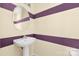 Powder room features stylish vanity with sink and striped yellow and purple wallpaper at 1032 Eagles Nest Ln, Indian Land, SC 29707