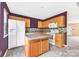 Well-lit kitchen features an island, modern appliances, and wood cabinets against a purple wall at 1032 Eagles Nest Ln, Indian Land, SC 29707