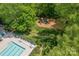 Aerial view of a community pool and playground, surrounded by mature trees and greenery at 11312 Fox Hill Dr, Charlotte, NC 28269